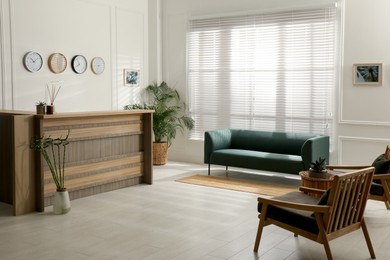 Photo of Hotel lobby interior with wooden reception desk. Stylish workplace