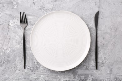 Elegant setting with stylish cutlery on grey textured table, flat lay