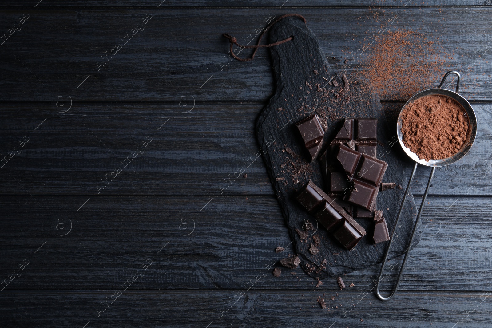 Photo of Flat lay composition with delicious dark chocolate on black wooden table. Space for text
