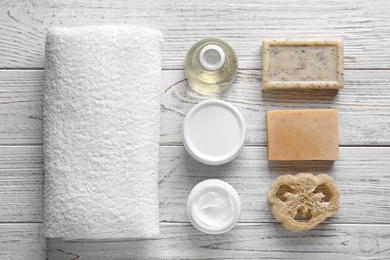 Photo of Flat lay composition with spa cosmetics and towel on wooden background