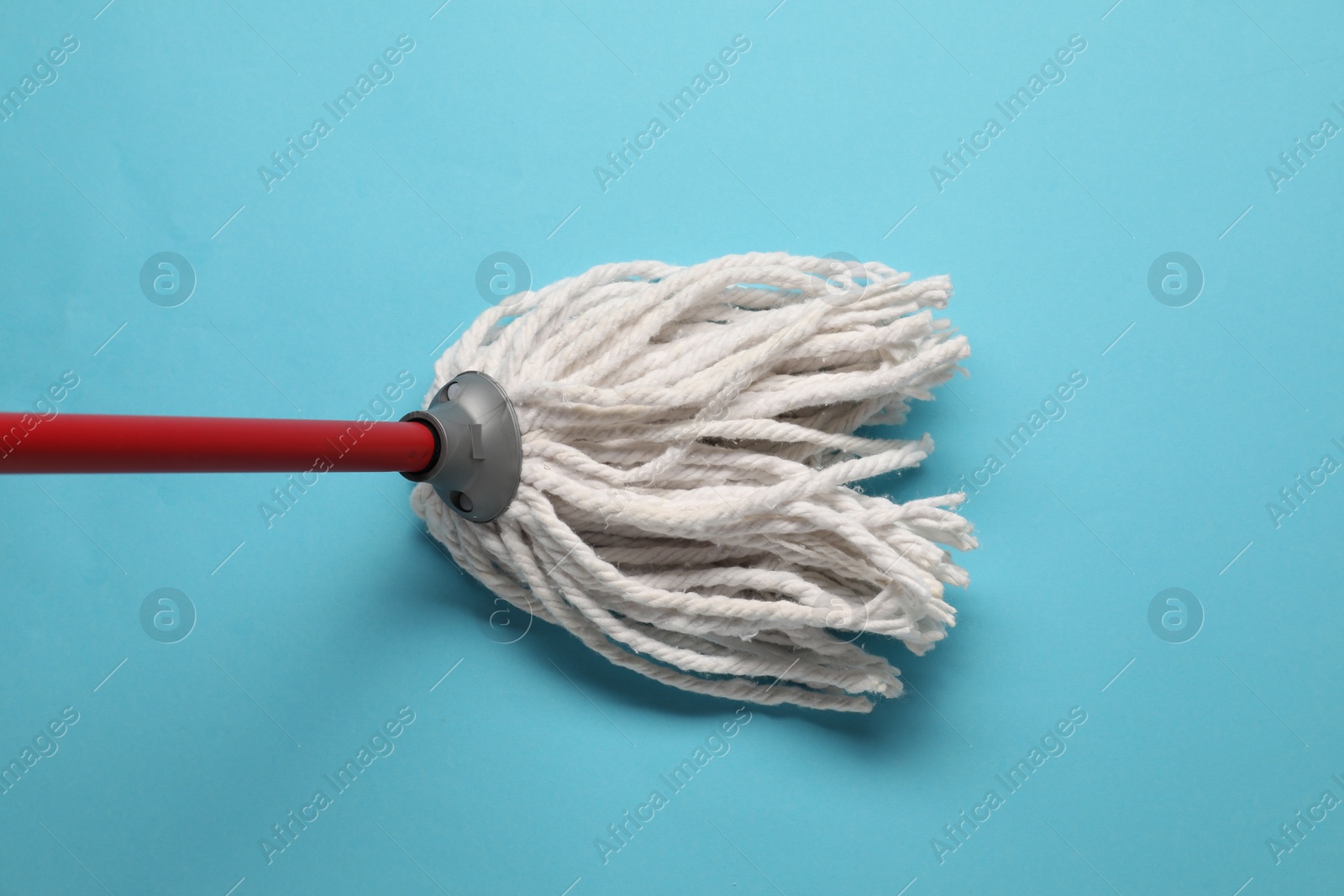 Photo of Mop with plastic handle on light blue background, top view