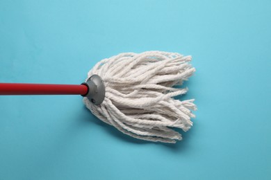 Mop with plastic handle on light blue background, top view