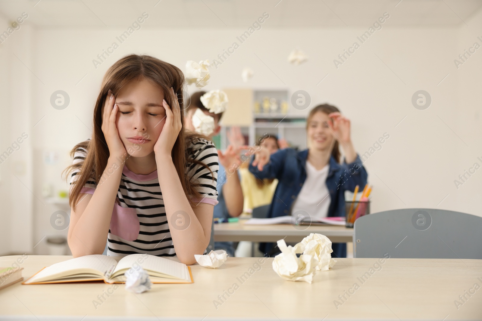 Photo of Teen problems. Students bullying their classmate in classroom, selective focus