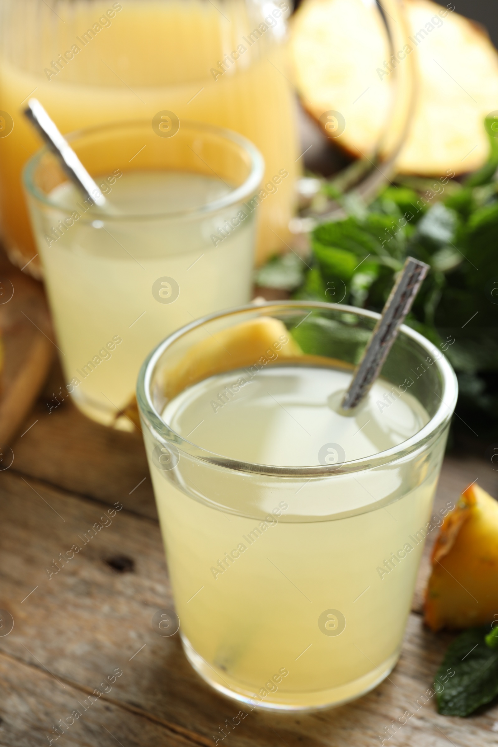 Photo of Delicious pineapple juice and fresh fruit on wooden table