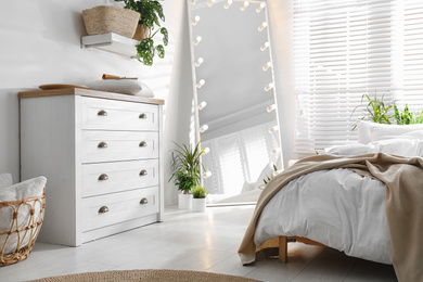 Photo of White chest of drawers in beautiful bedroom. Interior design