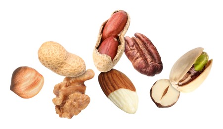 Image of Many different nuts in air on white background