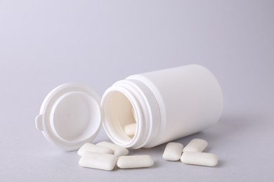 Jar with chewing gums on light grey background