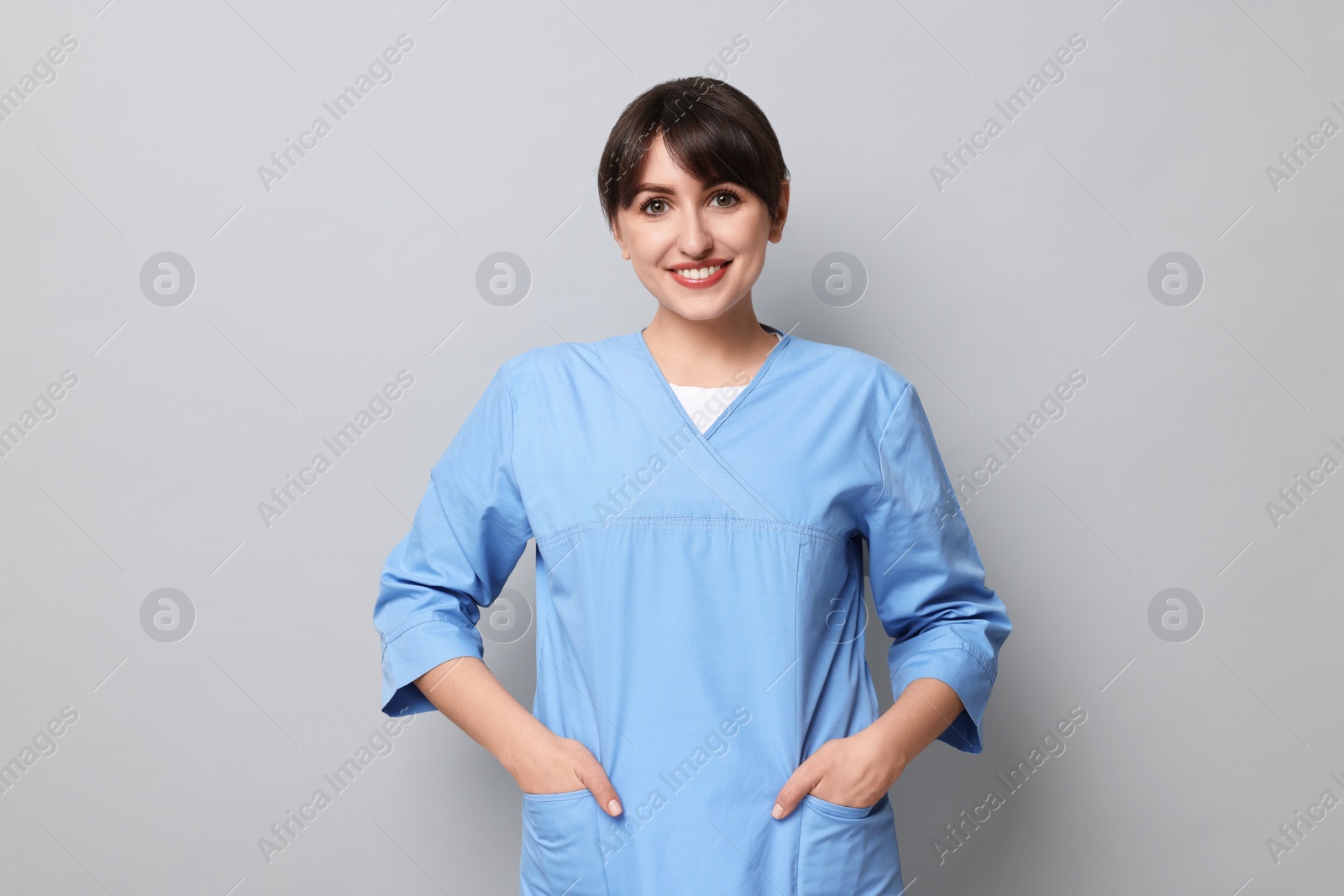 Photo of Portrait of smiling medical assistant on grey background