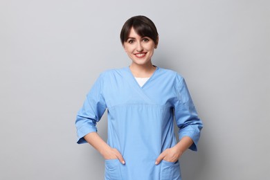 Photo of Portrait of smiling medical assistant on grey background