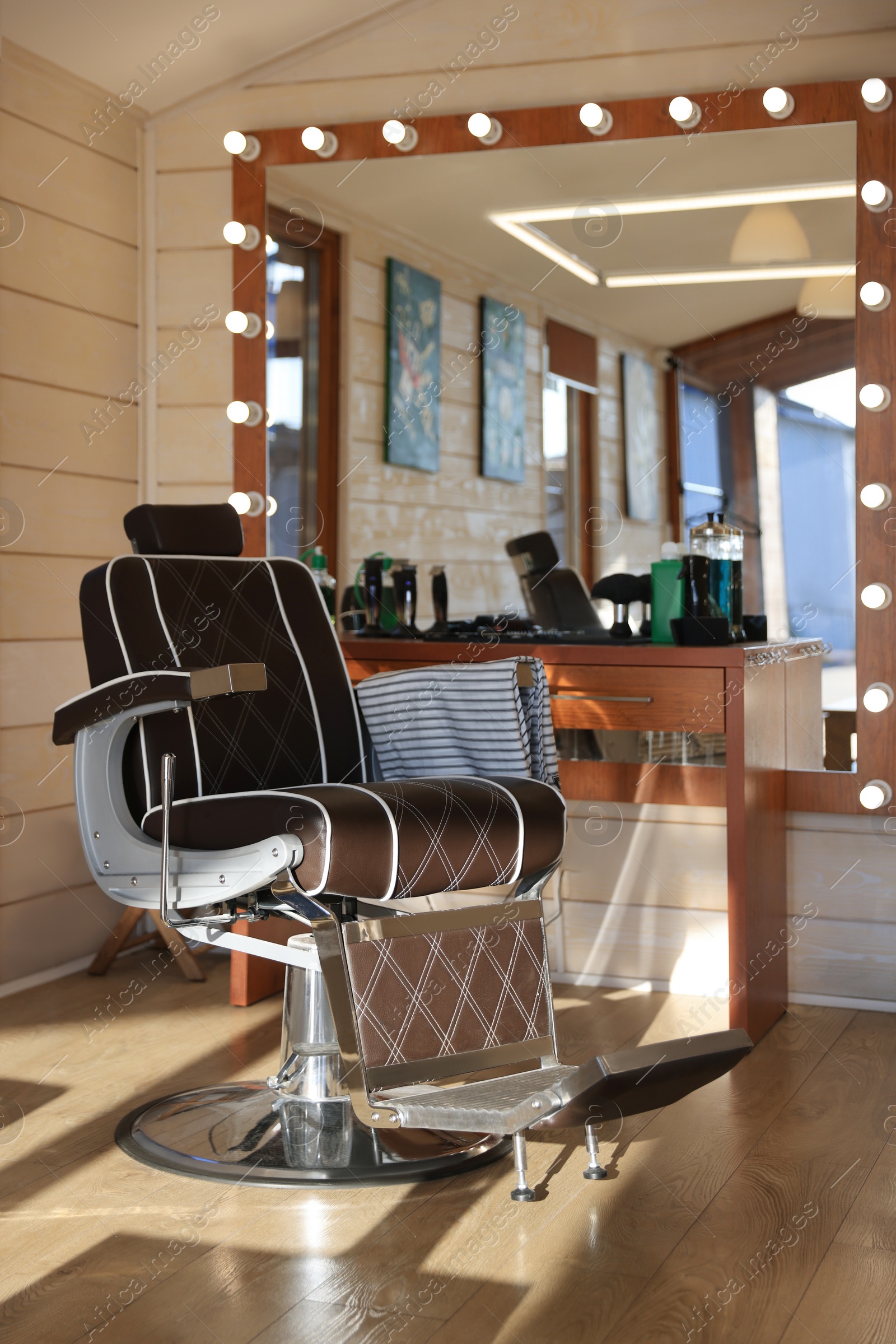 Photo of Stylish hairdresser's workplace with professional armchair in barbershop