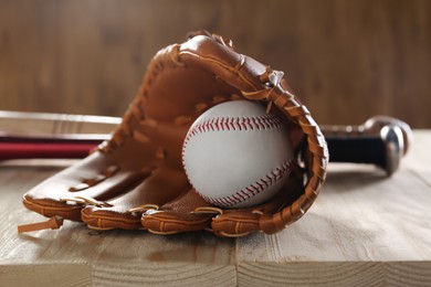 Photo of Baseball glove ball on wooden table, closeup