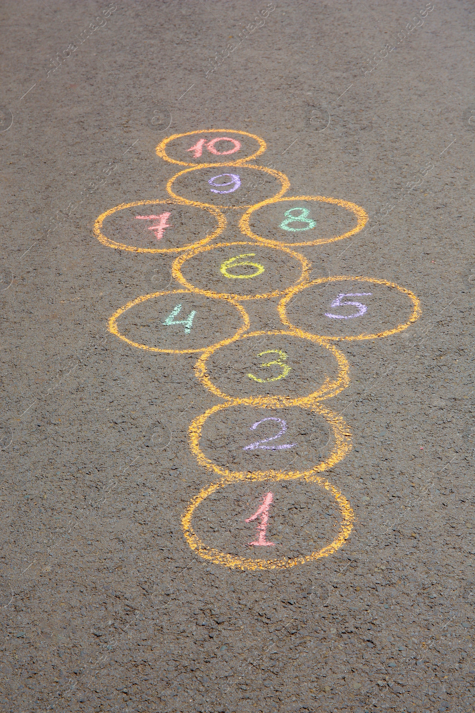 Photo of Hopscotch drawn with colorful chalk on asphalt outdoors