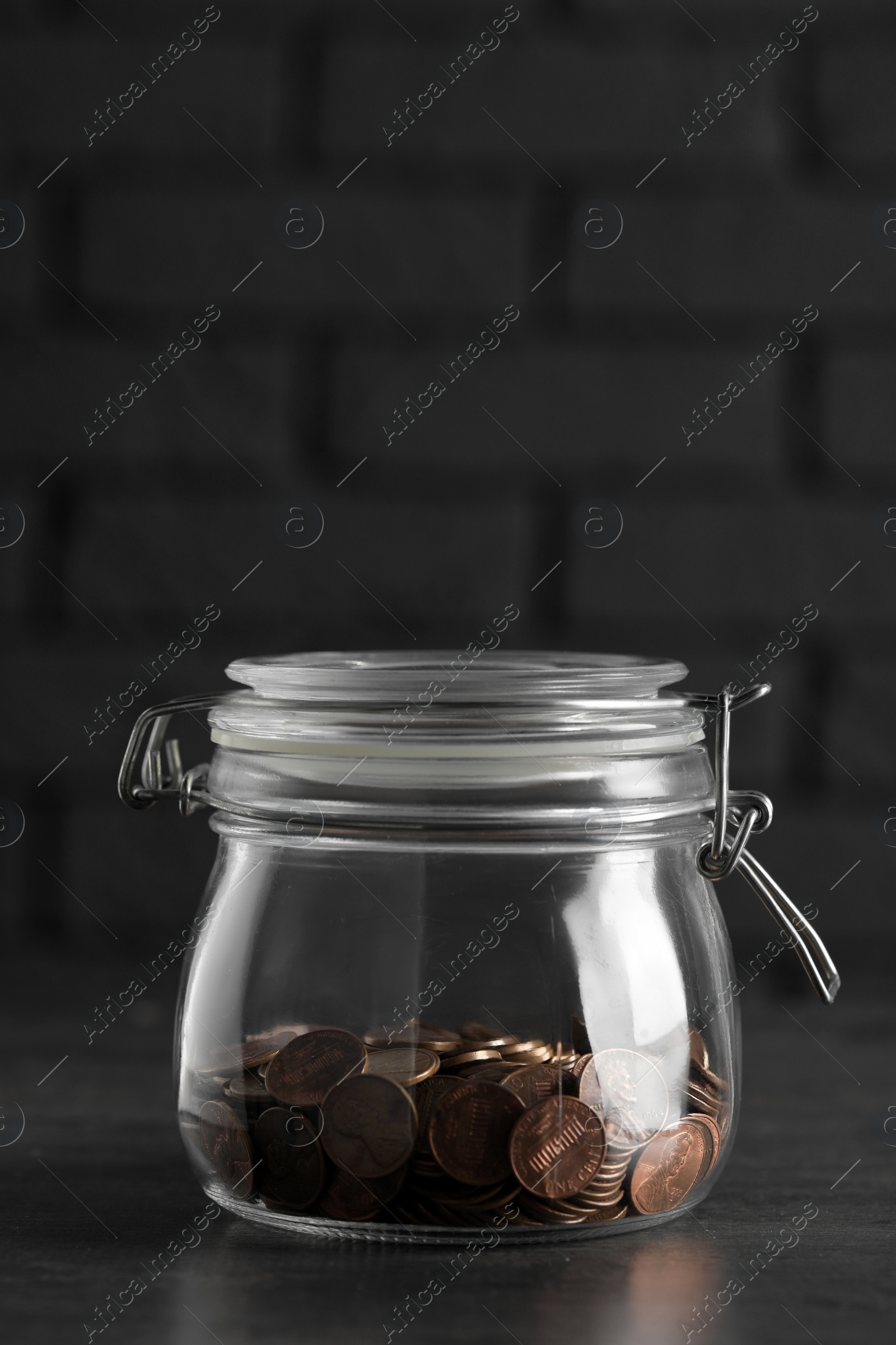 Photo of Glass jar with coins on grey table, closeup