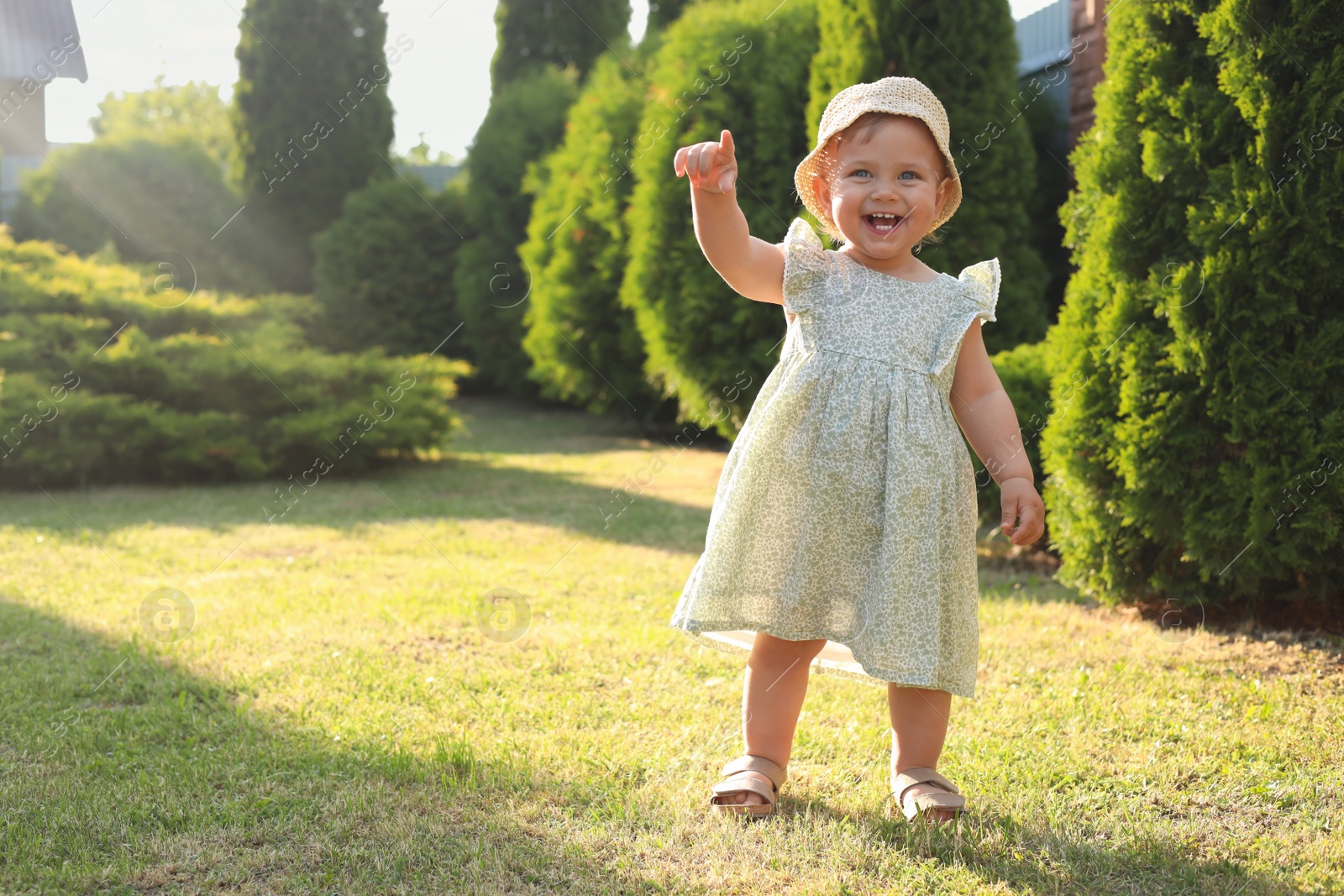 Photo of Cute little girl wearing stylish clothes outdoors on sunny day. Space for text