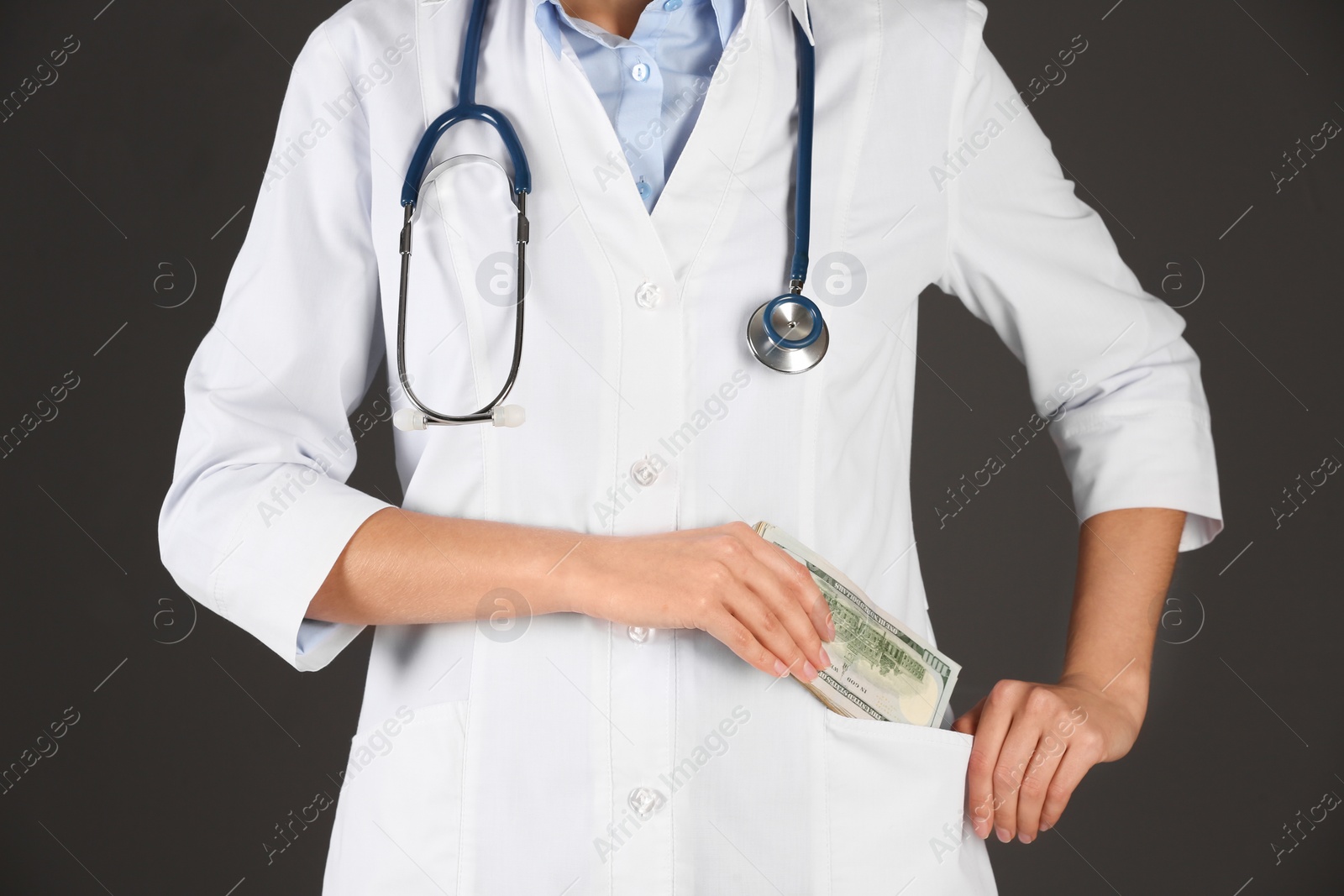 Photo of Doctor putting bribe into pocket on black background, closeup. Corruption in medicine