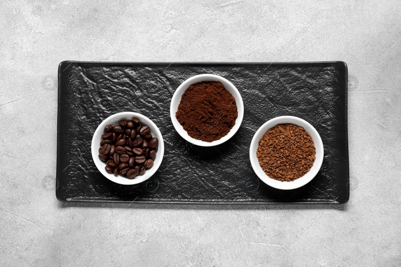 Photo of Bowls with different types of coffee on light grey table, top view
