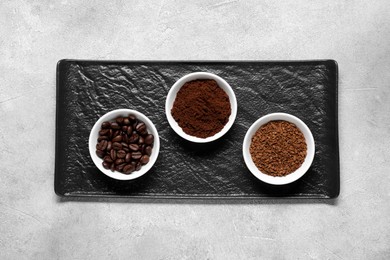 Photo of Bowls with different types of coffee on light grey table, top view