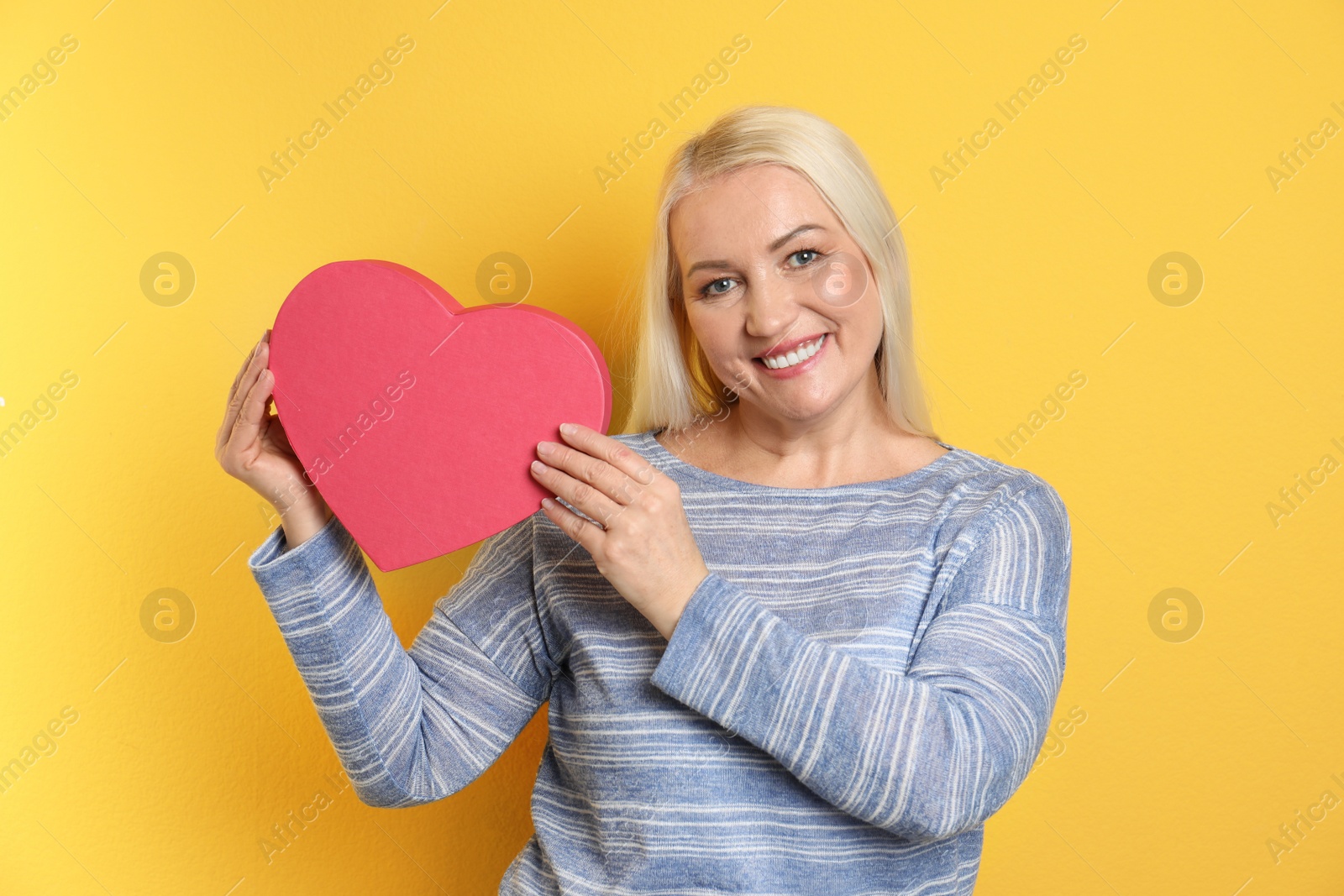 Photo of Portrait of mature woman with decorative heart on color background