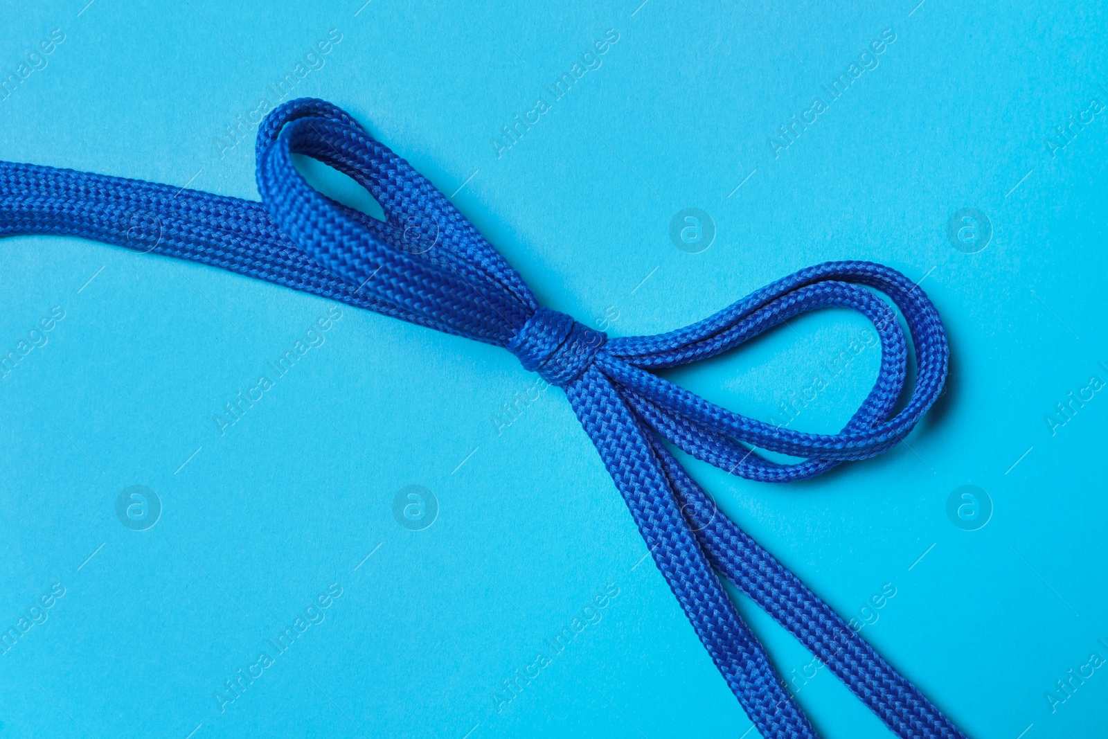 Photo of Shoelaces on light blue background, top view