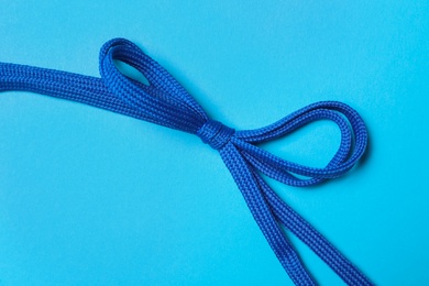 Shoelaces on light blue background, top view
