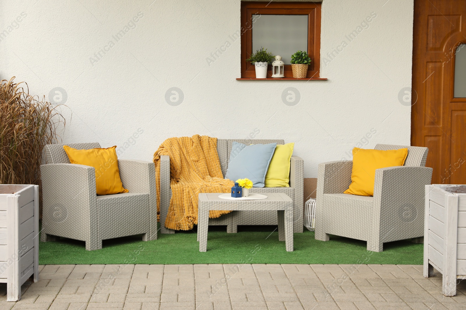 Photo of Beautiful rattan garden furniture and different decor elements outdoors