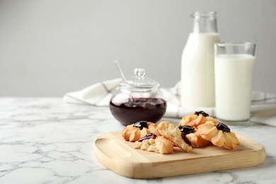 Photo of Tasty shortbread cookies with jam on white marble table