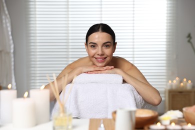 Beautiful happy woman relaxing on massage table in spa salon