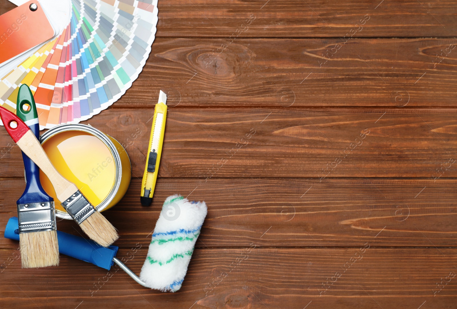 Photo of Set of decorator's tools on wooden background, flat lay