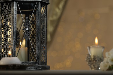 Photo of Arabic lantern and burning candles against blurred lights, space for text