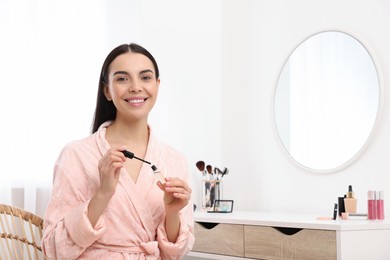 Photo of Beautiful young woman with eyebrow gel indoors
