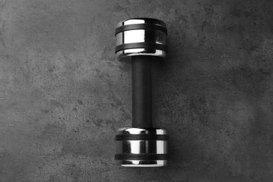 Photo of One dumbbell on grey table, top view