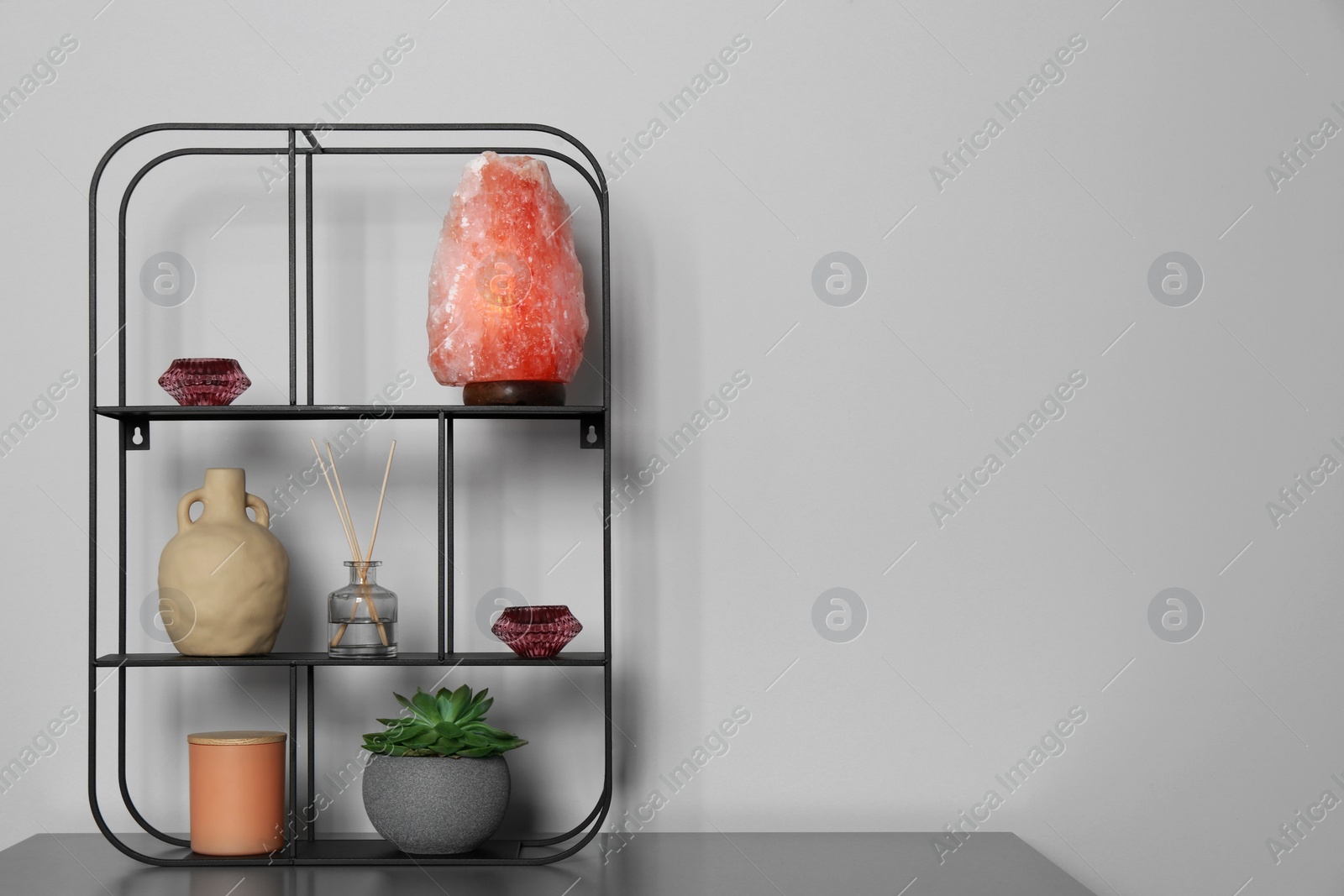 Photo of Shelving unit with decorative elements on chest of drawers, space for text. Interior design