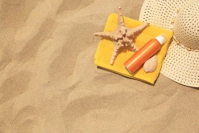 Flat lay composition with sunscreen on sand, space for text. Sun protection care