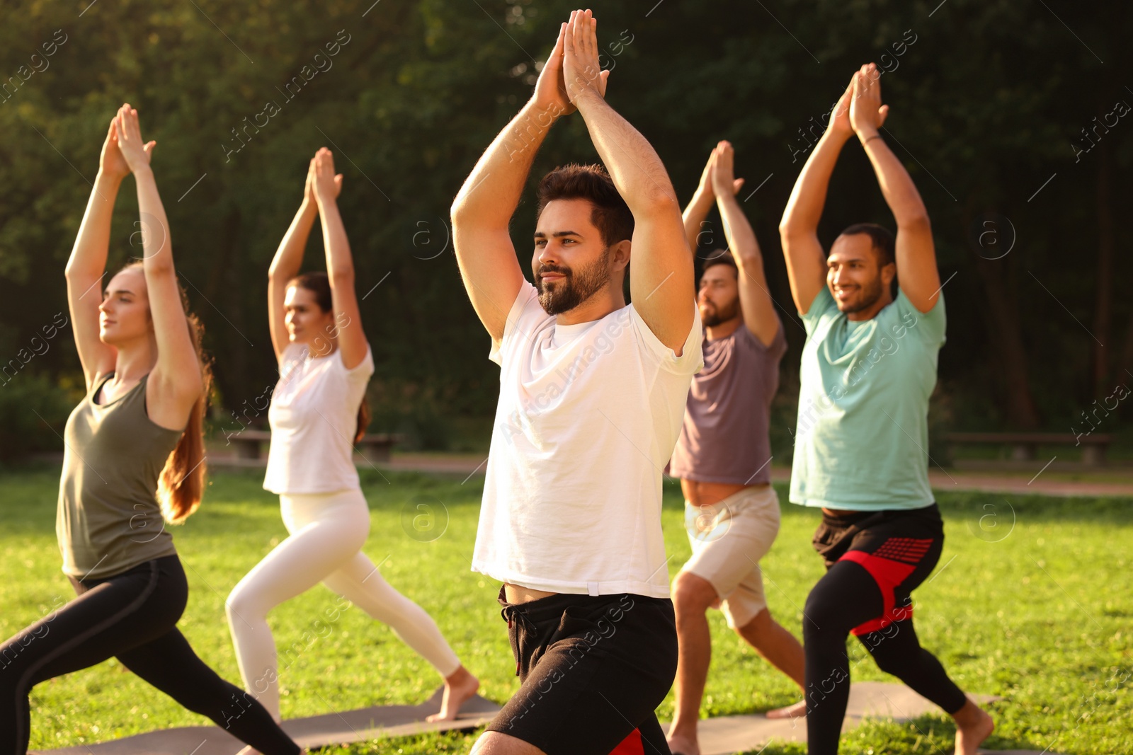 Photo of Group of people practicing yoga on mats outdoors