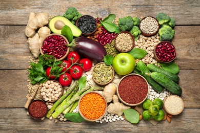 Photo of Different vegetables, seeds and fruits on wooden table, flat lay. Healthy diet