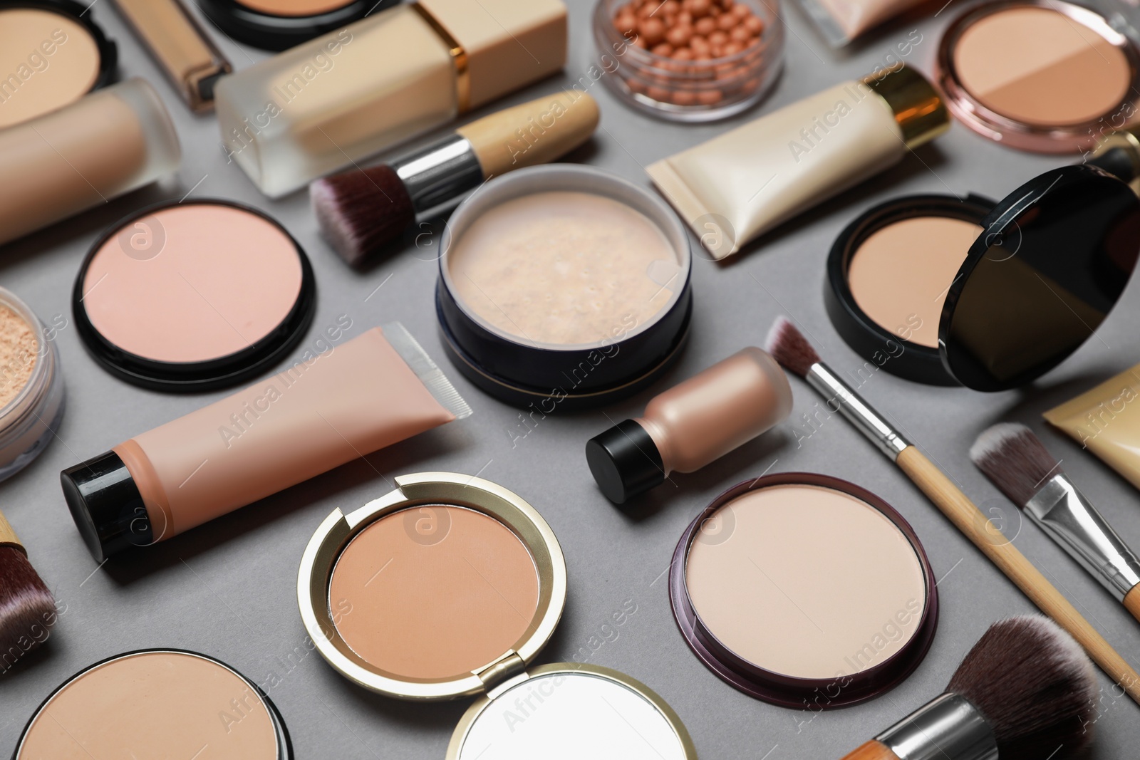 Photo of Face powders and other makeup products on grey background