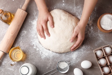 Female baker preparing bread dough at kitchen table, top view