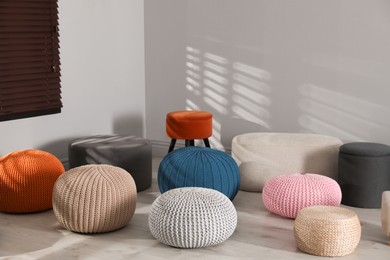 Many stylish different poufs in room. Home design