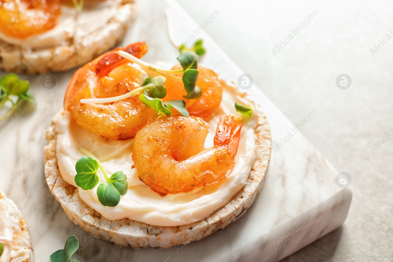 Photo of Delicious small sandwich with shrimps on marble board, closeup