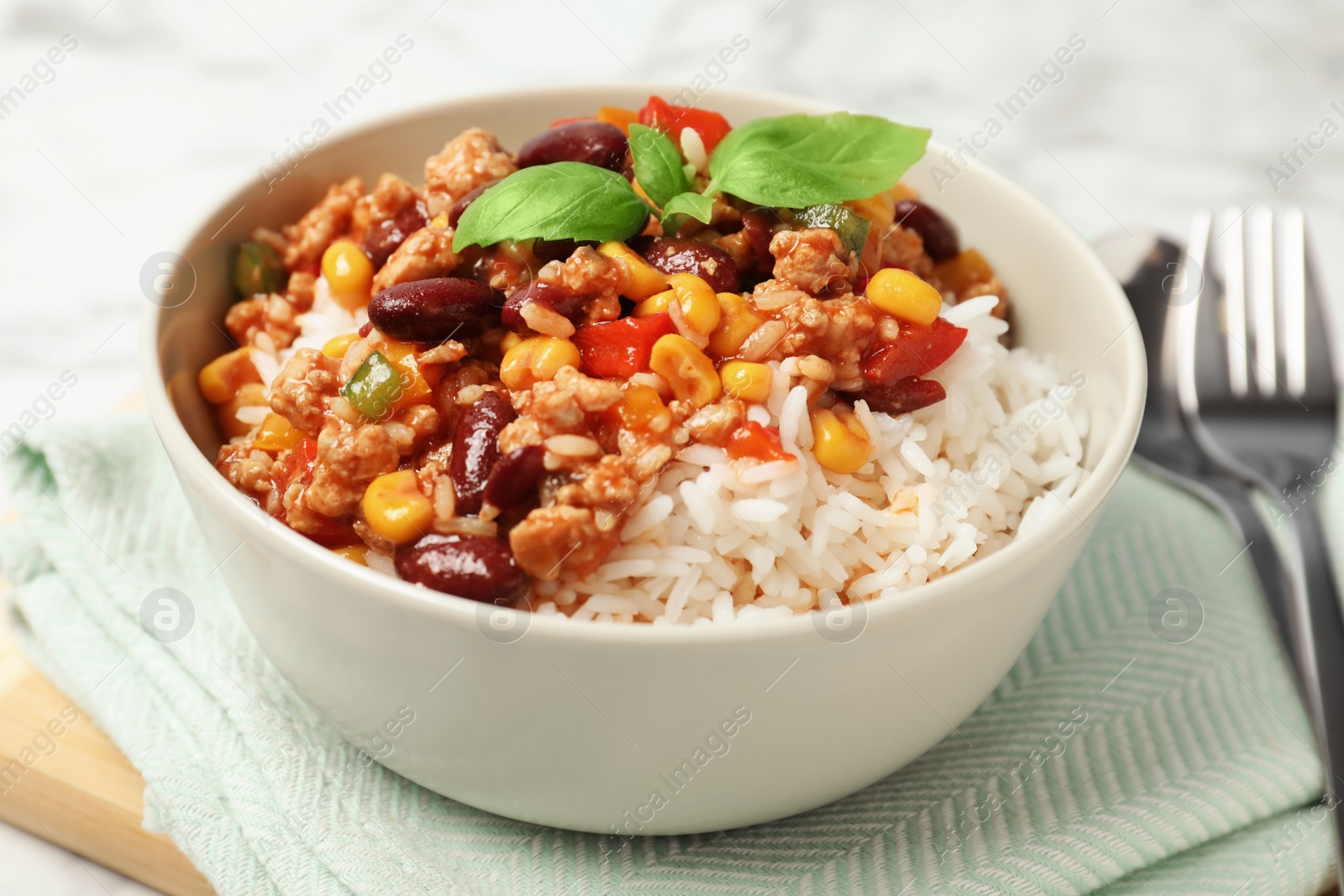 Photo of Tasty chili con carne served with rice in bowl on table