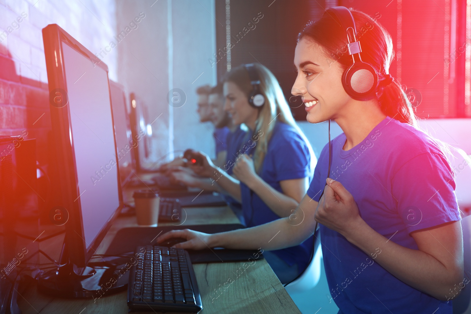 Photo of Group of people playing video games in internet cafe, color tone