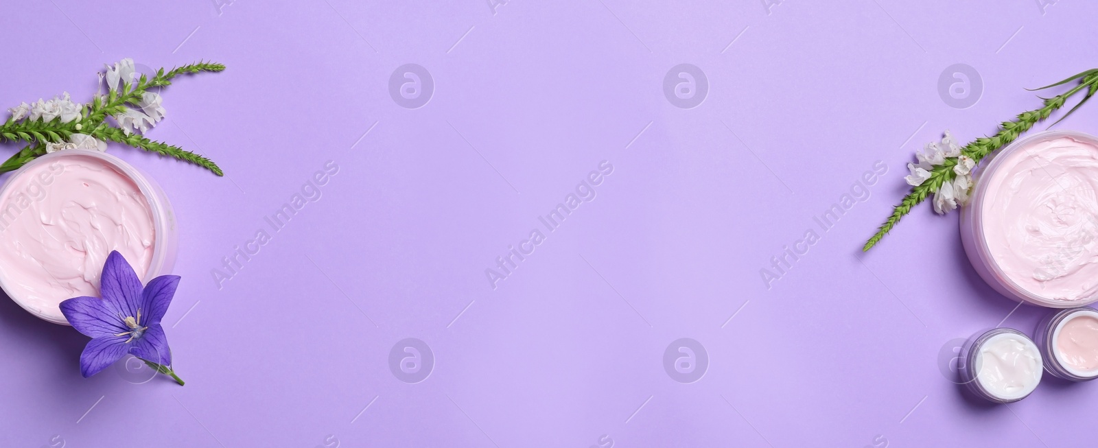 Photo of Flat lay composition with jars of body cream on lilac background. Space for text