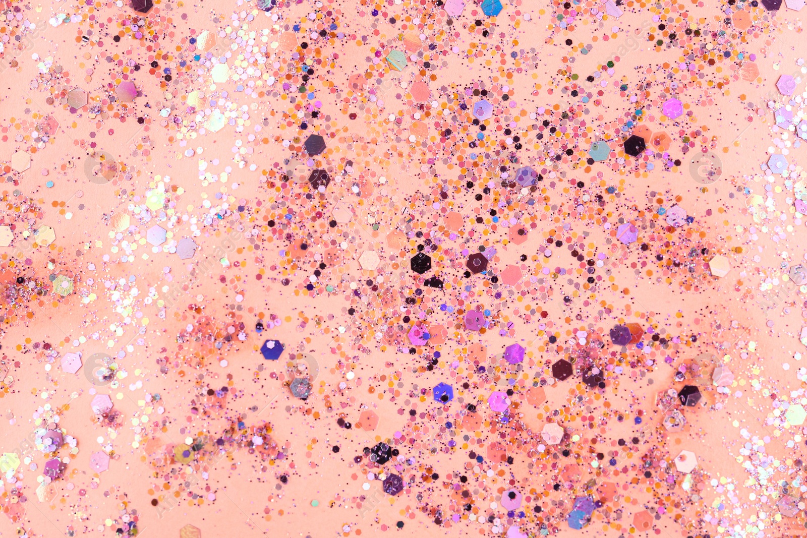 Photo of Shiny glitter on light pink background, top view