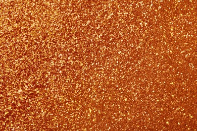 Beautiful shiny orange glitter as background, closeup