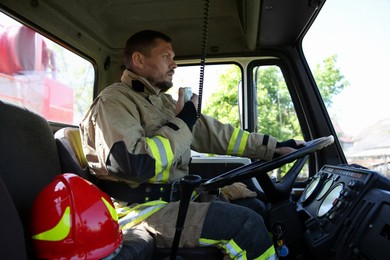 Firefighter using portable radio set while driving fire truck