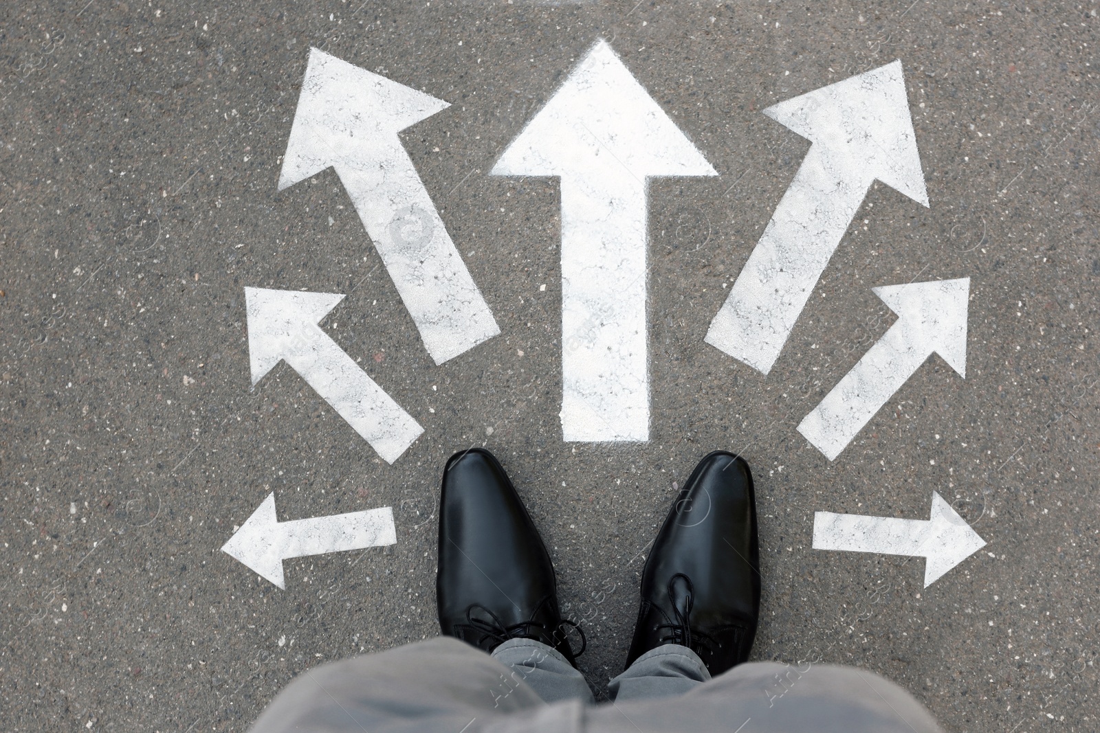 Image of Man standing on road near arrows, top view 