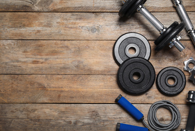 Photo of Gym equipment on wooden background, flat lay. Space for text