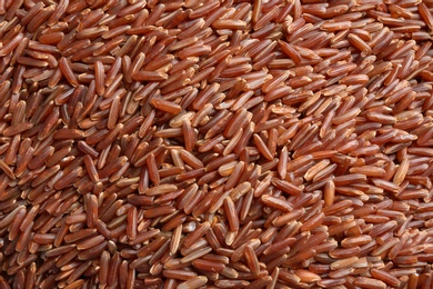 Photo of Raw brown rice as background, closeup view