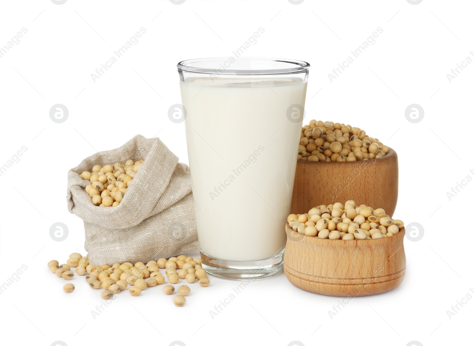 Photo of Glass of fresh soy milk and beans on white background