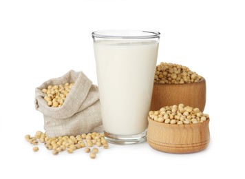 Photo of Glass of fresh soy milk and beans on white background